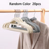 A set of 20 random color velvet slim hangers hanging on a wooden rod.