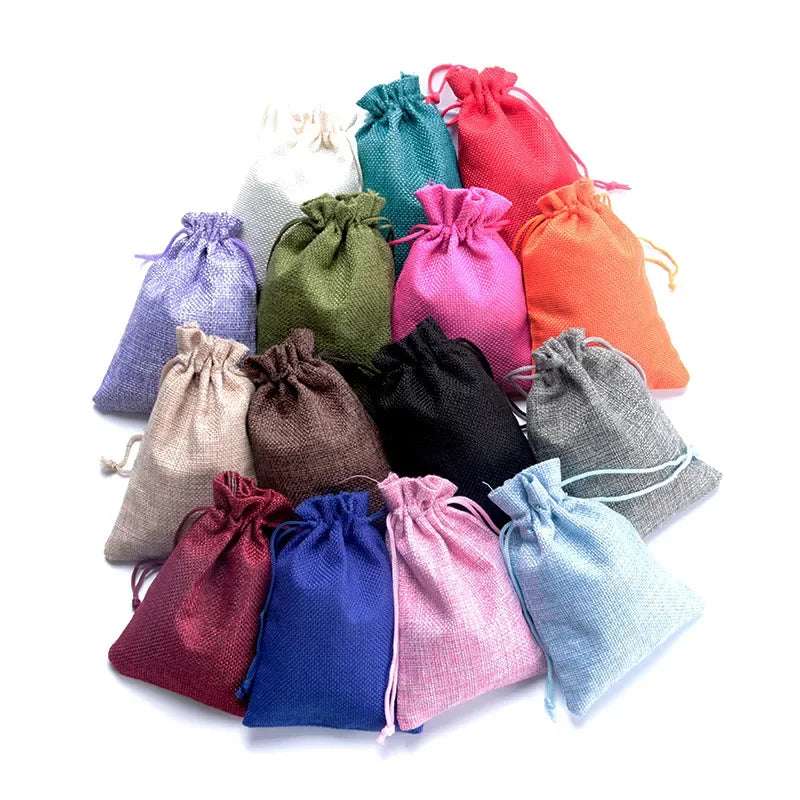 Eine Kollektion handgemachter Jute- und Leinen-Geschenktüten in verschiedenen Grüntönen, Pink-, Violett-, Orange- und Schwarz