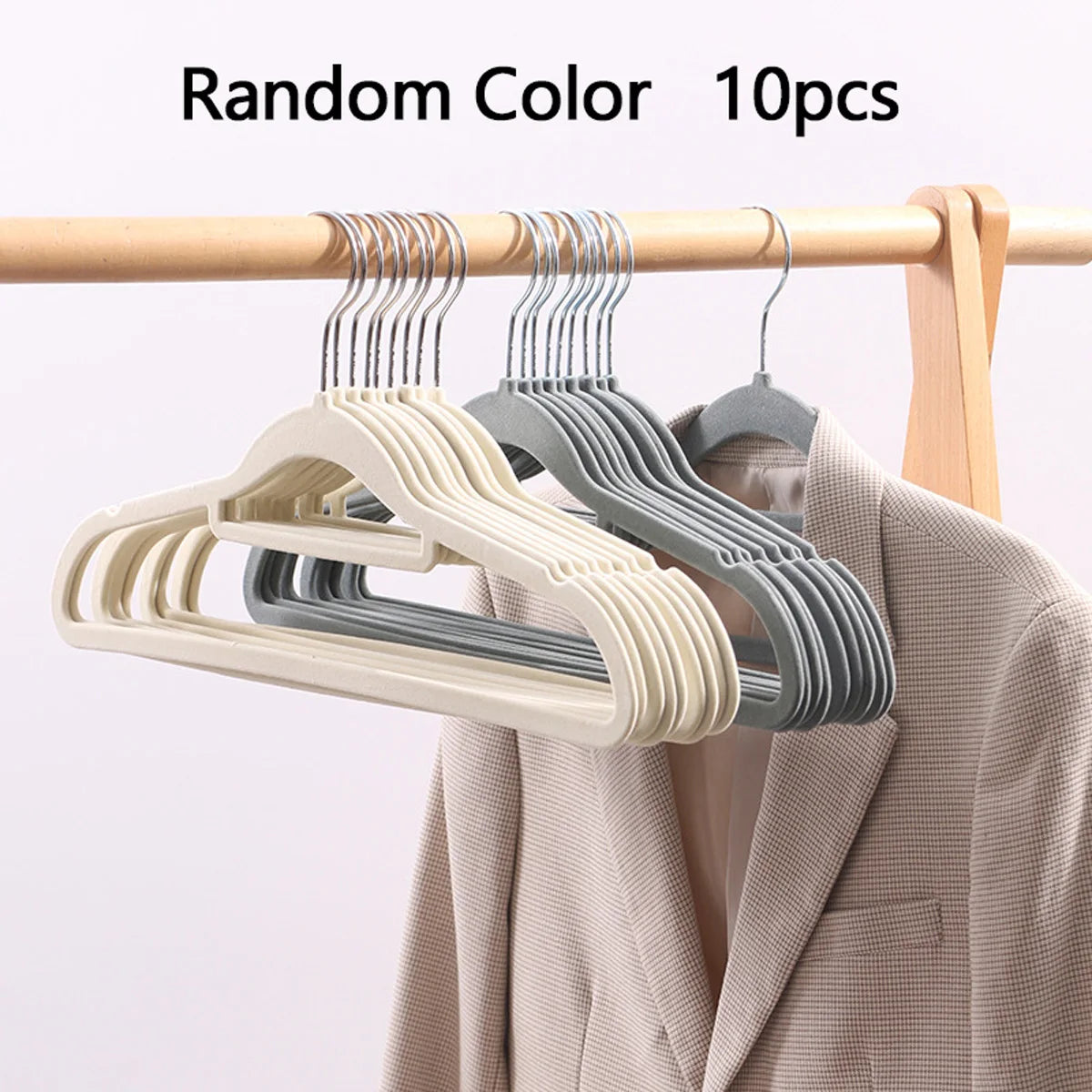 Ten random color velvet slim hangers hanging on a wooden rod next to a jacket.
