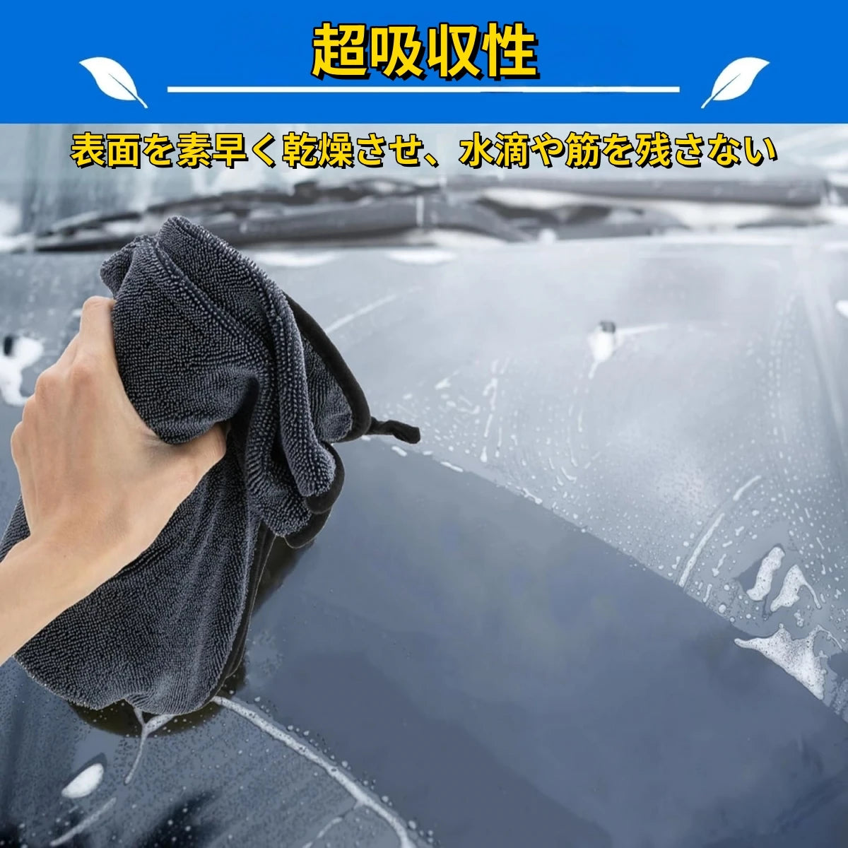 A hand is using an extra large microfiber drying towel to wipe a car surface, demonstrating its absorbency.