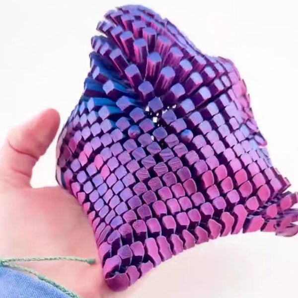 Eine Hand hält ein lila 3D gedrucktes, artikuliertes Seestern-Fidget-Spielzeug mit einer strukturierten, schuppenartigen Ober