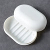 A white portable soap holder with a lid is shown open, displaying ribbed compartments for holding soap.