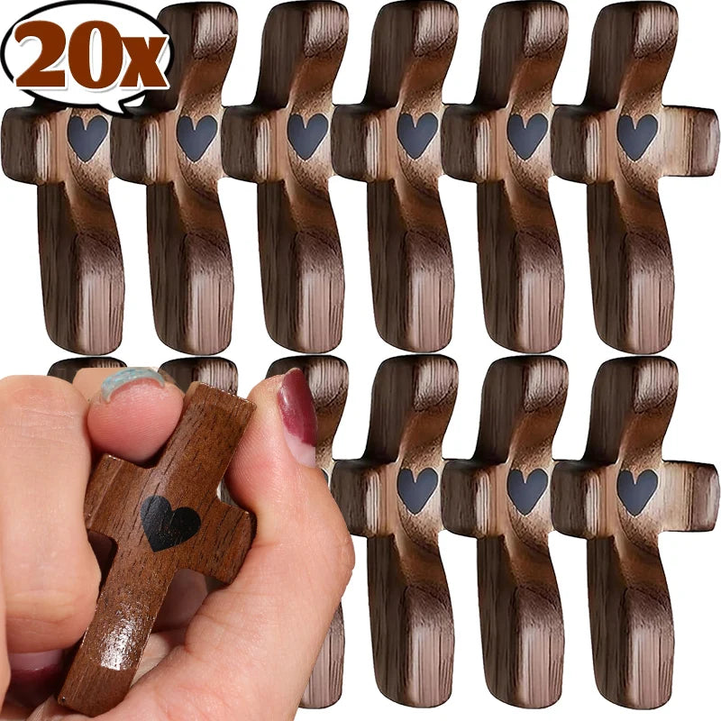 Une main tient un ornement de prière en bois miniature avec un cœur sculpté au centre.