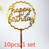 A gold acrylic birthday cake topper with the words happy birthday on a stick.