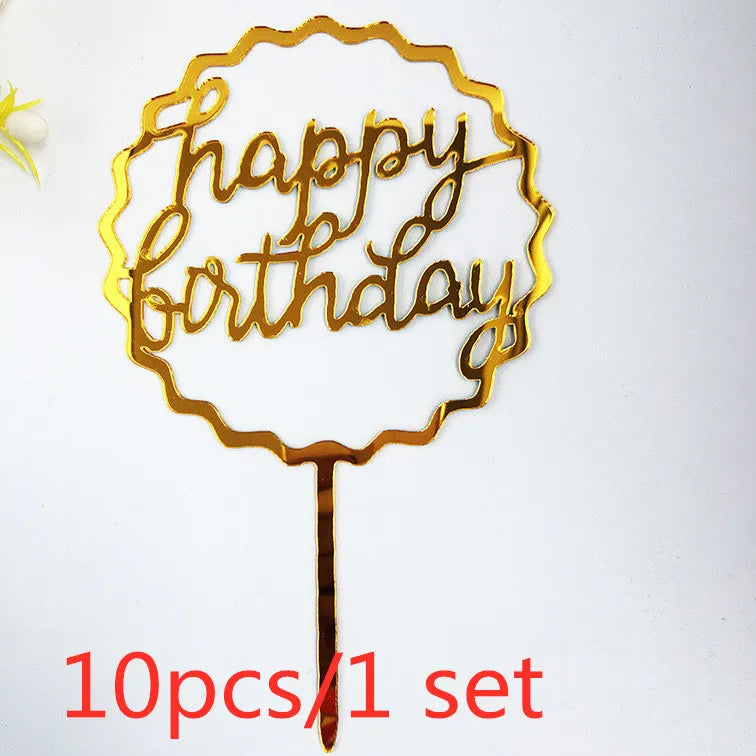 A gold acrylic birthday cake topper with the words happy birthday on a stick.