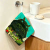 A green fabric towel featuring a Totoro cartoon design is hanging on a wall.