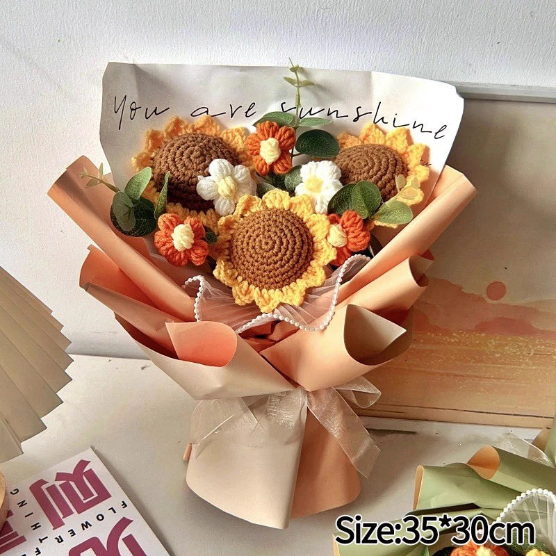 A handmade crochet flower bouquet featuring orange and yellow flowers wrapped in natural paper.