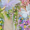 A vertical floral arrangement featuring pink and purple flowers and large, translucent butterfly decorations.