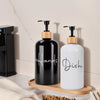 A black and white hand soap dispenser bottle is displayed on a wooden tray.