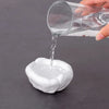 A hand pours clear liquid from a glass into a white clay plug to demonstrate sealant.