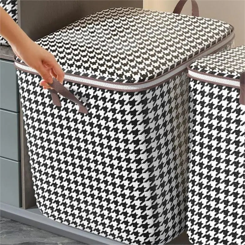 Une main ouvre un sac de rangement pour vêtements pliable et anti-poussière à motif noir et blanc à carreaux.