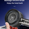 A hand holds a massage silicone brush shower head against a dark blue background.