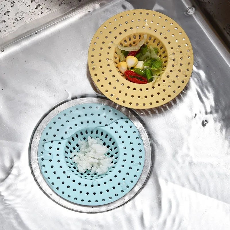 A stainless steel kitchen sink drain strainer with a yellow perforated plate and a blue perforated plate for draining.