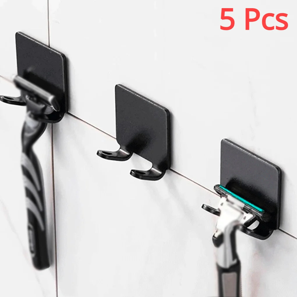 Five black aluminum shaving razor storage racks mounted on a white tile wall.