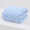 A light blue thickened microfiber bath towel folded on a white surface.