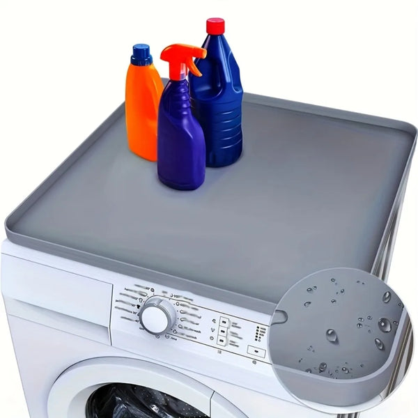 Three colored bottles are placed on the top surface of a white washer dryer with a silicone protector mat.