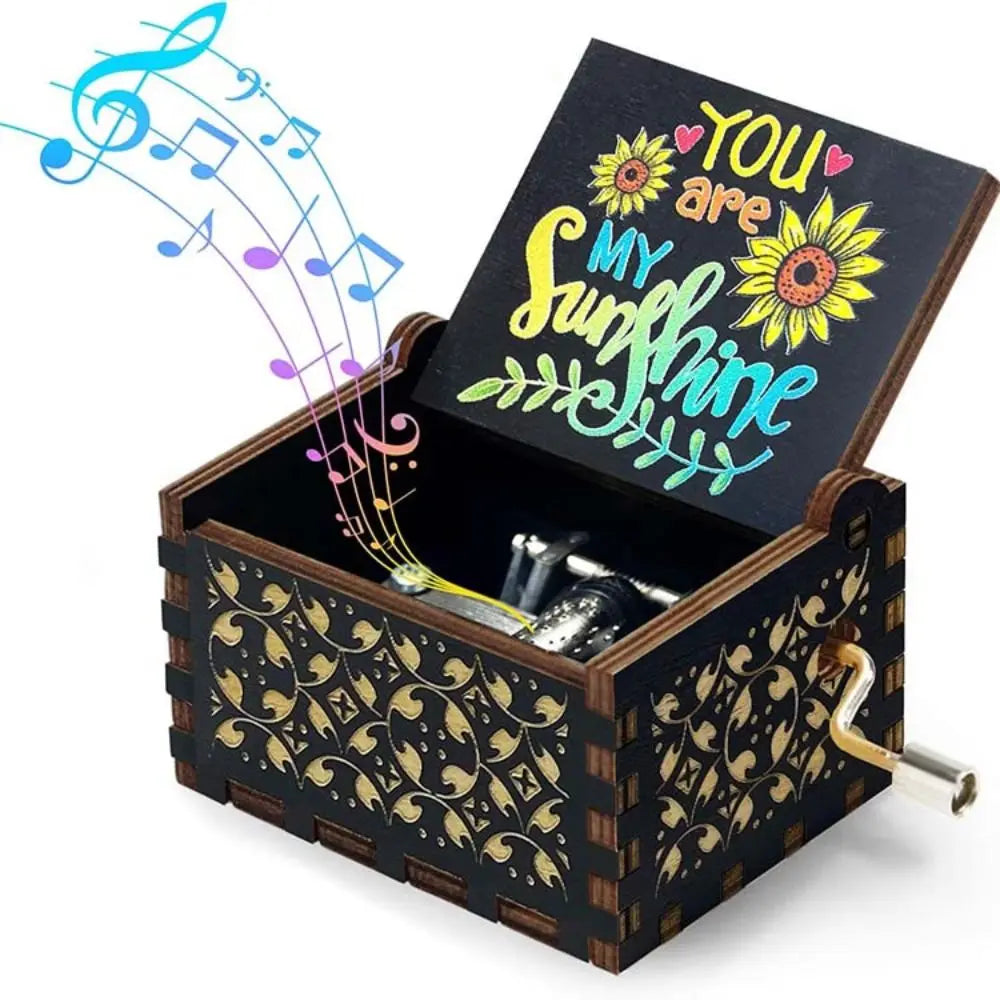 A vintage engraved wooden music box with a lid open, featuring a sunflower design and musical notes.