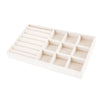 A white velvet jewelry organizer tray with multiple compartments and a drawer.