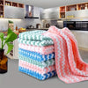 A stack of thick coral and pink velvet cleaning cloths on a kitchen counter.
