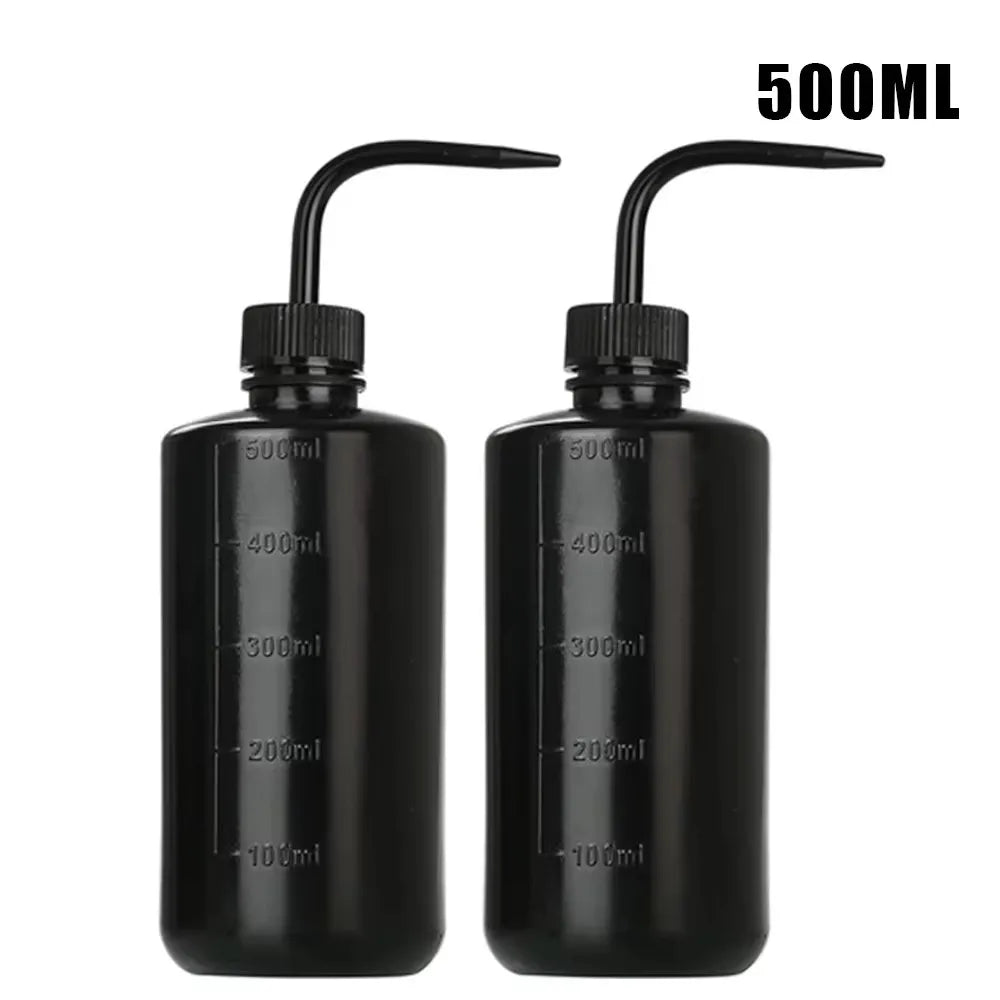 A pair of black squeeze bottles with measurement lines for tattoo solutions