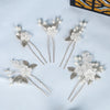 A set of silver pearl flower bridal hair clips displayed on a light blue background.