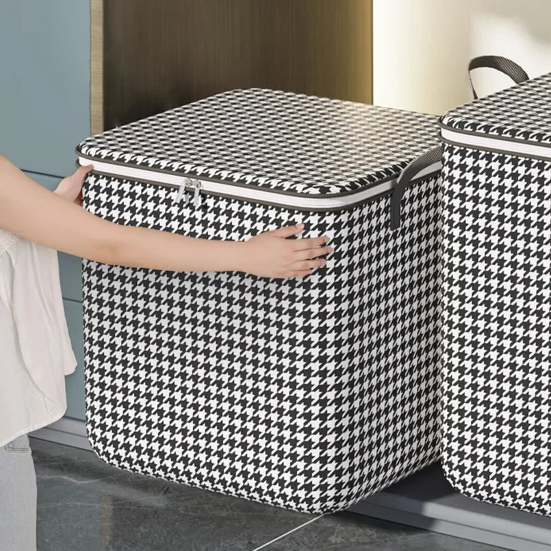 A hand is opening a black and white checkered non-woven quilt storage box with a clear window.