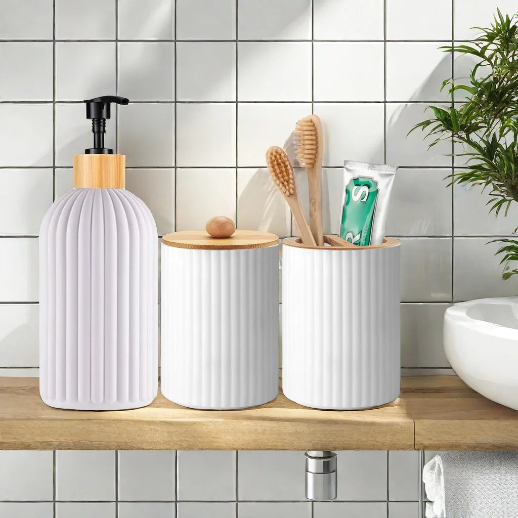 A set of white ceramic bathroom countertop organizers including a pump dispenser and toothbrushes on a wooden shelf.