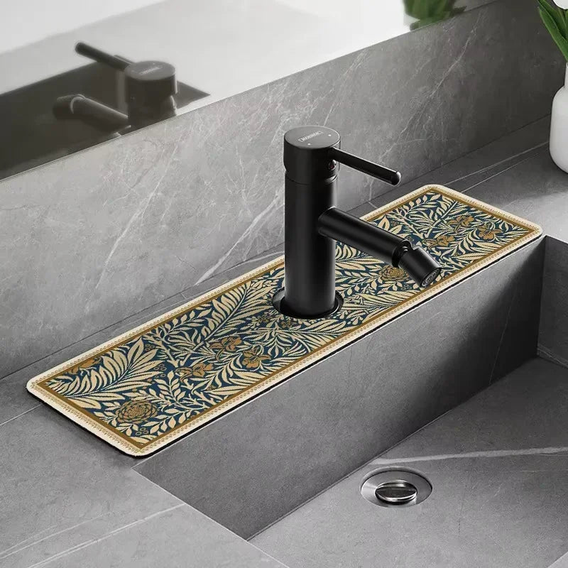 A matte black faucet mounted on a gray countertop with a decorative mat featuring gold and blue botanical patterns.