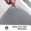 Close-up of a gray non-slip TPR backing bath mat texture being touched by a hand.