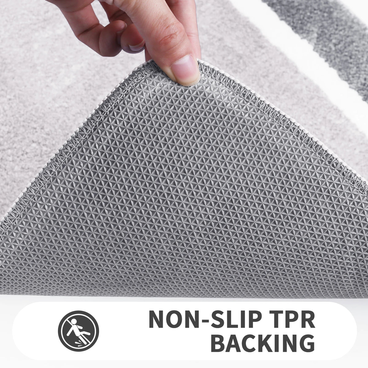 Close-up of a gray non-slip TPR backing bath mat texture being touched by a hand.
