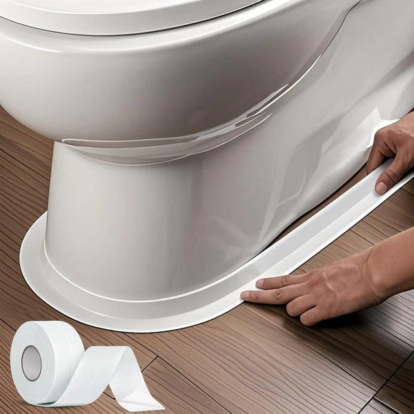 A hand applies heavy-duty waterproof caulk tape to seal the base of a white toilet bowl.