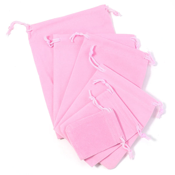 A stack of pink velvet drawstring jewelry bags.