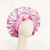 Pinker Seiden-Haube aus Satin, mit Schleife, auf einem Mannequin-Kopf präsentiert.