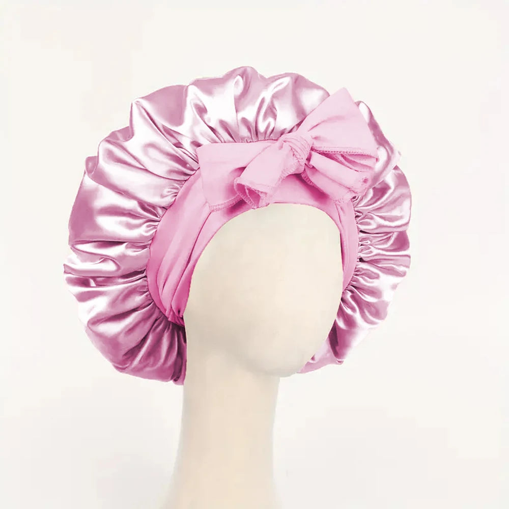 Pinker Seiden-Haube aus Satin, mit Schleife, auf einem Mannequin-Kopf präsentiert.
