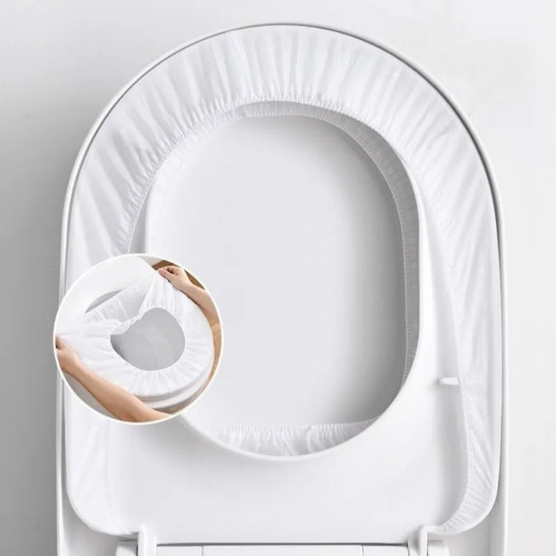 A white disposable toilet seat is shown in an oval, curved packaging design.