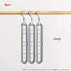 Three grey foldable plastic hangers hanging from a wooden rod.