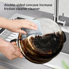 Hands are using a double-sided concave friction cleaner to clean a pot in a kitchen sink.