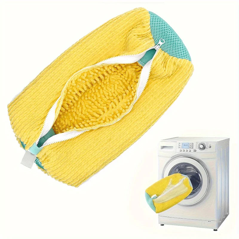 Yellow mesh shoe wash bag with a zipper placed next to a washing machine.