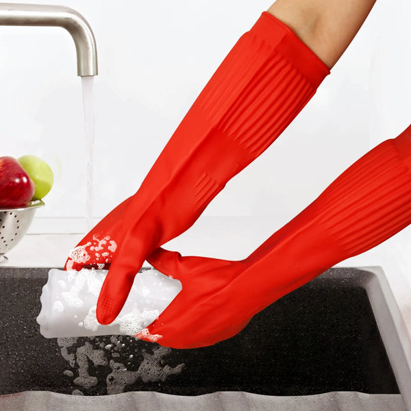 A hand wearing red silicone dishwashing gloves is cleaning forks in a black sink.