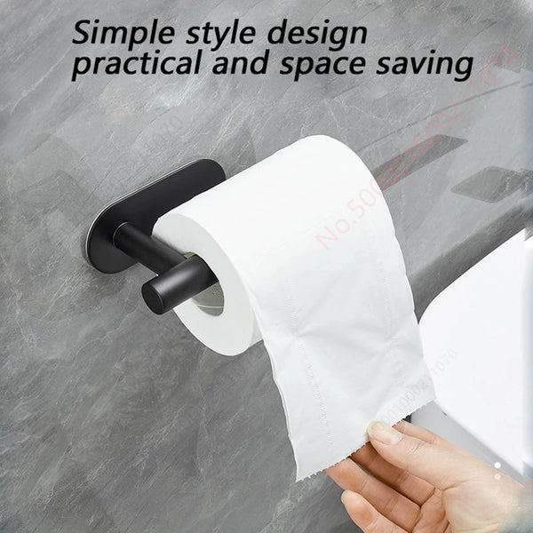 A hand is pulling a roll of white paper from a black stainless steel adhesive dispenser rack.