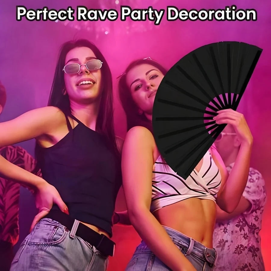 A woman in a black top is holding a black folding fan with a classic design.