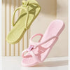 Une paire de tongs pliables en EVA vert clair et rose, montrées sur un fond clair.