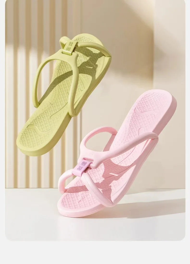 Une paire de tongs pliables en EVA vert clair et rose, montrées sur un fond clair.