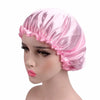 A pink satin sleep bonnet displayed on a mannequin head.