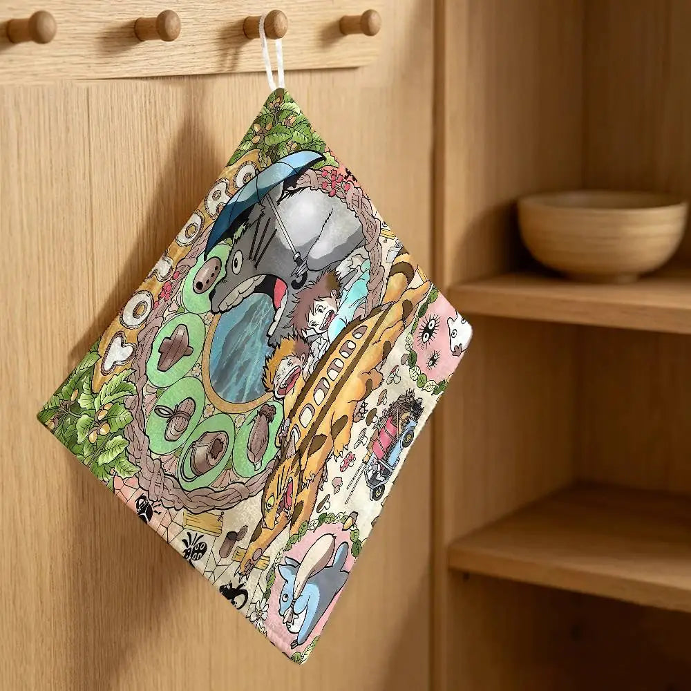 A cute Totoro cartoon-themed fabric towel hanging on a wooden cabinet.