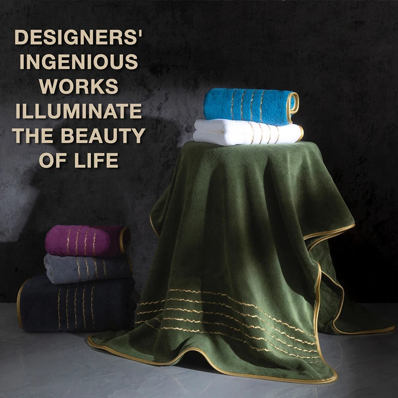 A stack of folded bath towels in teal, white, and purple rests on a draped olive green towel.