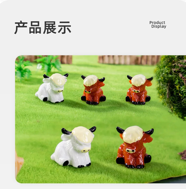 A display of resin highland cow figurines in various colors and poses on green grass.