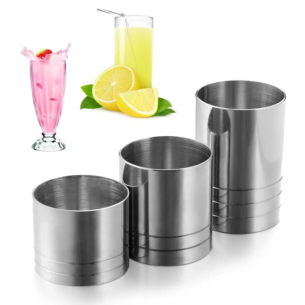 Stainless steel bar measures including a pink cocktail and a yellow citrus slice