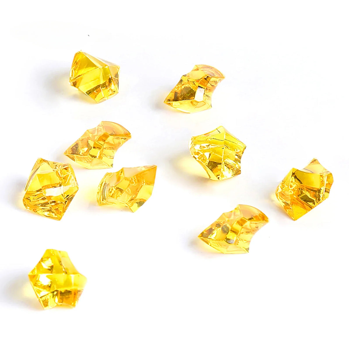 Several faceted yellow crystal crushed ice stones scattered on a white background.