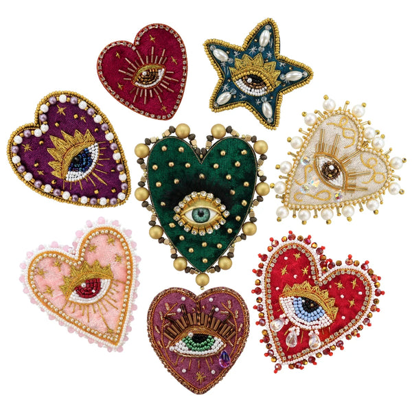 A collection of hand sewed beaded rhinestone appliqués shaped like hearts and stars in various colors including red, green, g